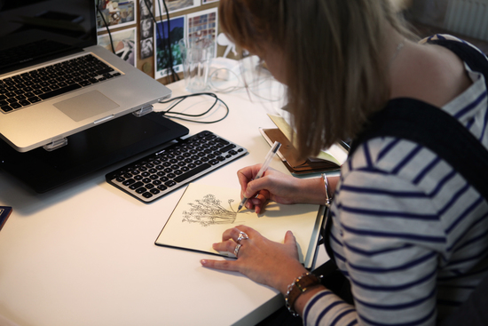 Blonde woman working drawing at a desk