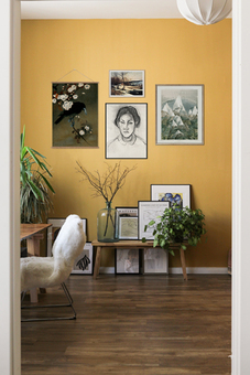 Gallery wall featuring vintage art on a mustard yellow wall