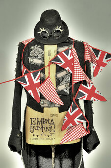 A steam punk themed mannequin wearing a leather jacket in an Alexander McQueen style. The mannequin is wrapped in Union Jack and Red Gingham Bunting