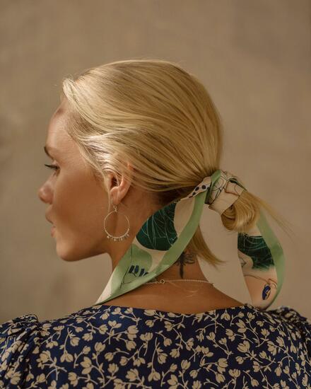 woman wearing a pistachio green thin silk scarf in her hair