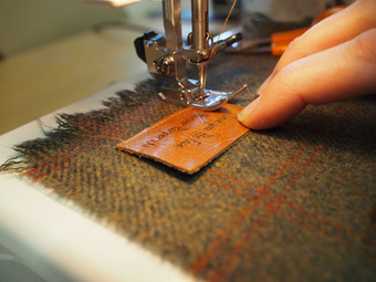 Sewing one of our personalised leather patches onto a scarf