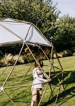 A young boy helps to build the geodesic garden pod