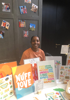 Image of Tihara Smith at an indoor craft market table with products on the table