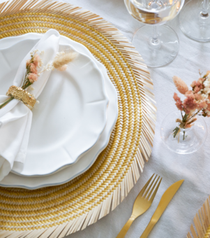 Gold woven natural straw placemat in an elegantly decorated dinner table