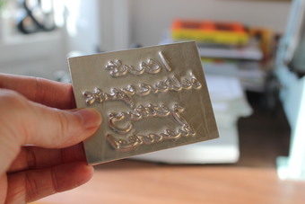 Each phrase is handwritten adn made into a metal die before being traditionally hand printed.