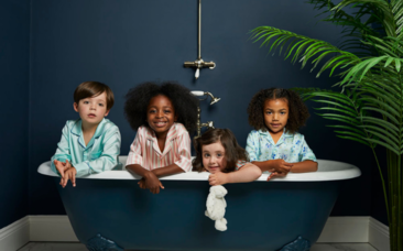 Four children wearing Sleepy Wilson pyjamas sitting in a bath