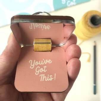 A keyring with a mirror on the inside and the encouraging words You've got this 