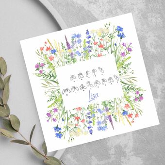A white card with beautiful watercolour wildflowers and the words Happy Birthday in BSL