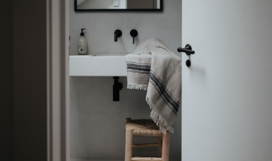 Luks - Ceren Linen Hamam Towel in black and taupe draped over bathroom sink
