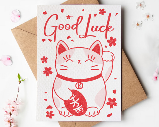A greetings card featuring a lucky waving cat in red
