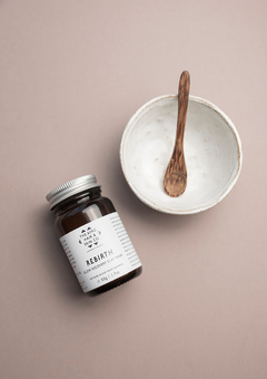 A small jar of rebirth flat mask with a ceramic bowl and wooden spoon