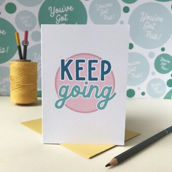White card with the words Keep going printed on the front in teal coloured text on a pink circle