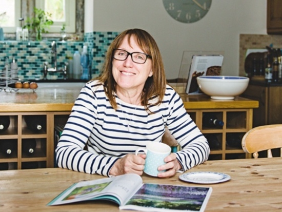 A picture of me (Jane) in my kitchen at Wadsley Hall Farm, sat at the kitchen table with a cuppa and a magazine!