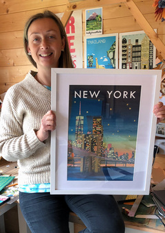 Collage artist Holly Anne Blake holding her completed New York City skyline collaged artwork