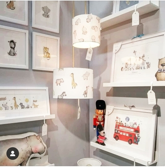 Children's luxury nursery interior designs displayed on a wall including kid's framed wall art prints of a london bus and safari animal lampshades