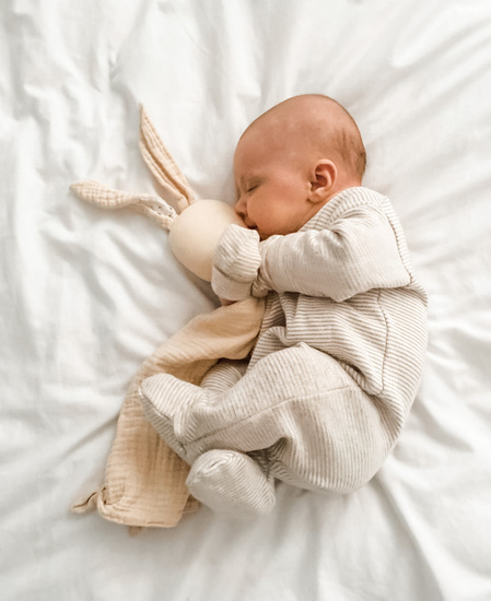 Baby hugging a soft muslin bunny comforter