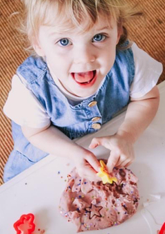 Excited girl with glitter birthday play dough
