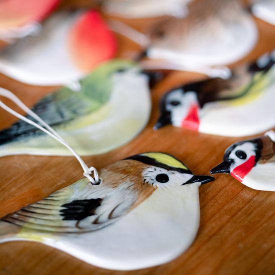 Porcelain hanging bird decorations on a table 