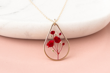 Handmade real flower necklace with red babys breath inside a clear resin