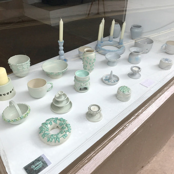 Handmade green and blue pottery in shop window
