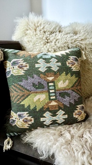 A southwestern green cushion with aztec leaf pattern