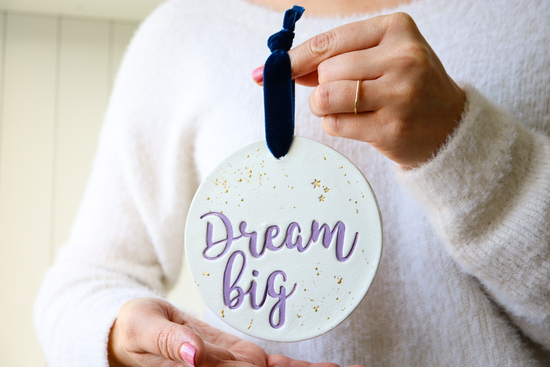 Dream big wall hanging, held by a lady's hands