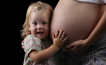 Girl with head on Mummy's tummy