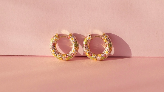 Set of hoop earrings leaning against a pink wall