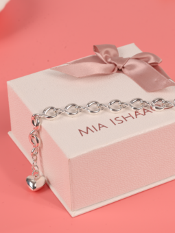 Silver twist chain bracelet laying over our signature gift box on a pink background - Mia Ishaaq