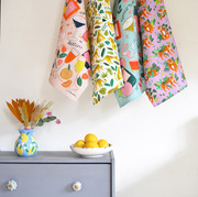 colourful tea towels by laura barnes hanging in kitchen