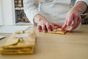 handwrapping of the chocolate bars in gold foil