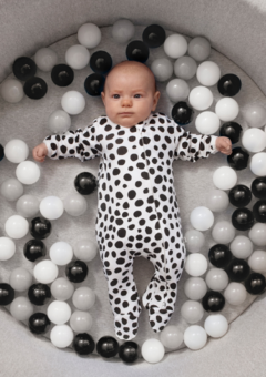 baby in black and white dalmatian print sleepsuit