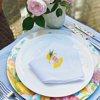 White linen hemstitch napkin with an embroidered image of Her Majesty the Queen