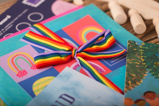 An open book club pack showing items included and wrapped in bright rainbow colours