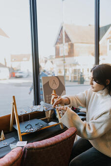 A photo of the business owner making jewellery at an event