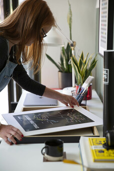 Helen, framing one of our iconic art prints.