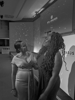 Co-founders Maria and Amone link arms at an award ceremony