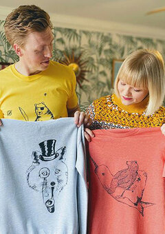 Lucy and Tom holding tshirts