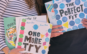 An image of Naomi and James holding some of their picture books