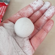 A picture of Seema's hand holding a ball of clay.