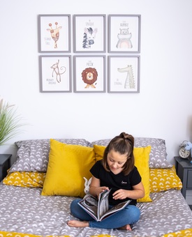 Child reading on bed in front of safari prints