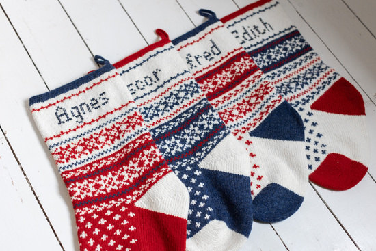 Red, blue and white fairisle knitted Christmas Stockings with hand embroidered names in cross stitch.