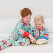 Image of two children reading a book wearing Ducky Zebra PJs