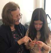 An image of Rejhane, one of the co-founders, teaching her niece to crochet, symbolising a family tradition passed down through generations.