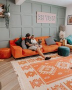 A southwestern orange rug with aztec diamond pattern in a large lounge