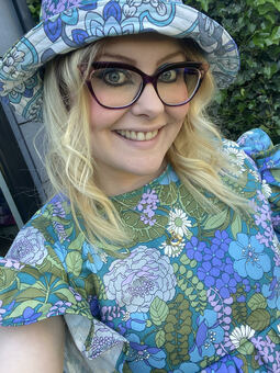 The founder of The Fruit Moth, Nicole Broad, wearing a handmade floral dress with a matching reversible bucket hat