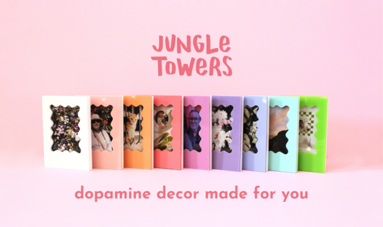 A line of Instax Mini frames lined up in a pleasing colour gradient. It has the Jungle Towers daisy shaped logo above, and says 'dopamine decor made for you'