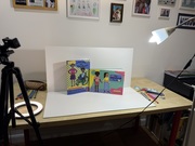 Set up of a photo shooting with two books set up next to each other to be photographed on a white backdrop surrounded by lights