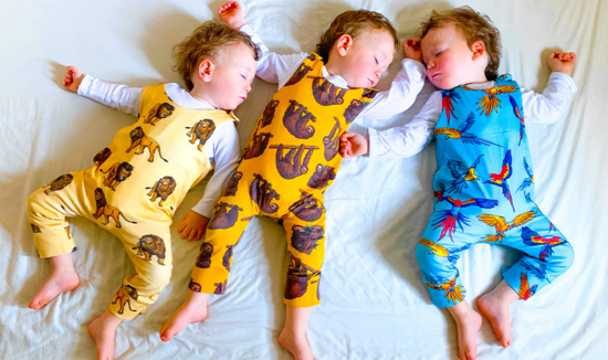 Three beautiful babies wearing our colourful sloth, lion and parrot prints 