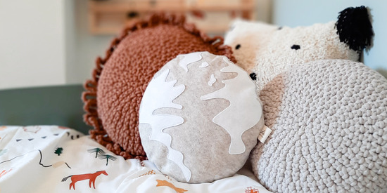 Earth Cushion pictured on a child's bed. 